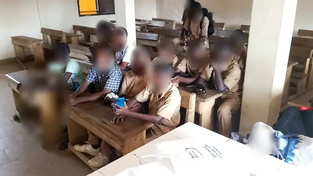 Un groupe d'élèves découvre l'application sur un téléphone.